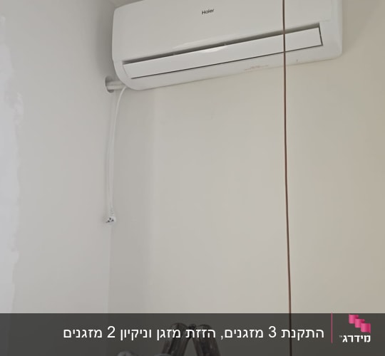 מזגן מותקן על קיר עם סולם לידו